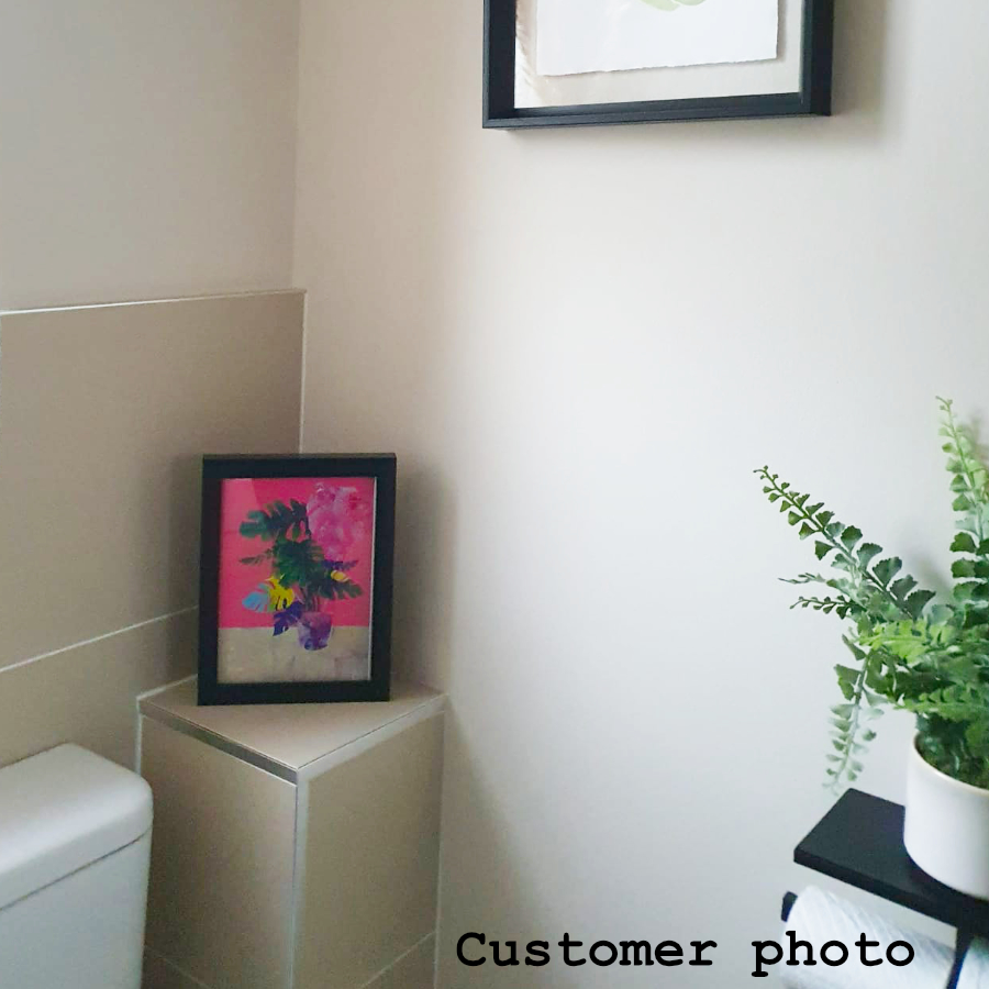 A customer photo of artist Rebecca Taylor's 'Monstera print' displayed in a bathroom.